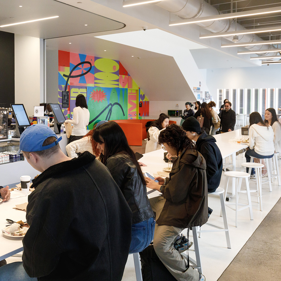 Students sitting at long table in cafeteria