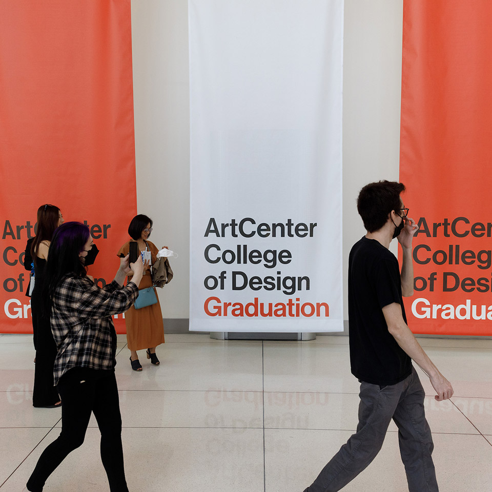 people walking by graduation banners