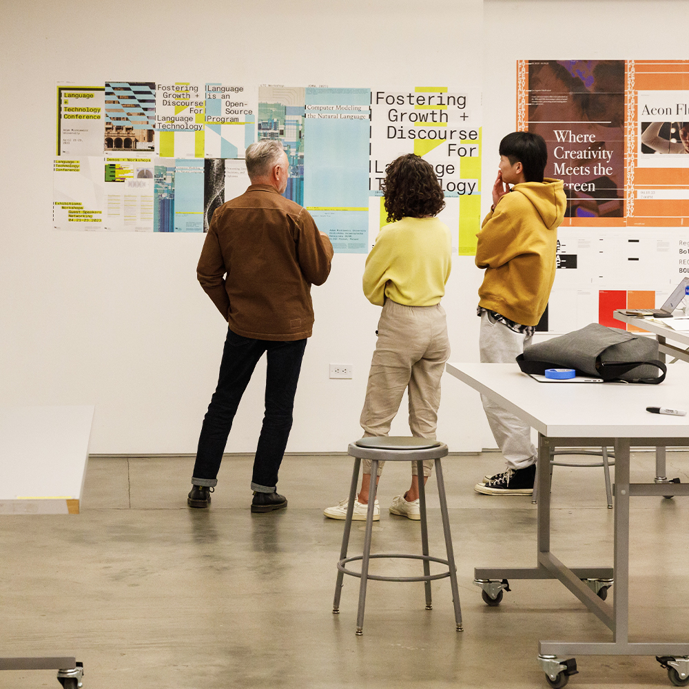Students and teacher viewing artwork displayed on the wall